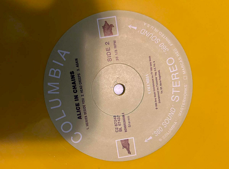 Yellow vinyl record with misaligned centre hole